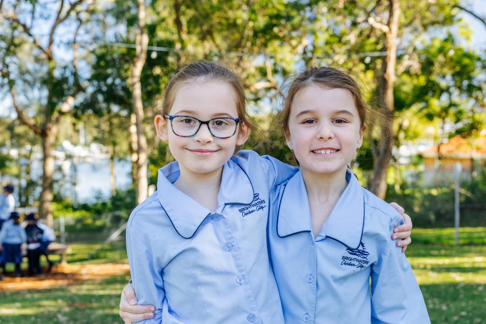 Two young Brightwaters CC students with arms around each other, showing kindness and friendship