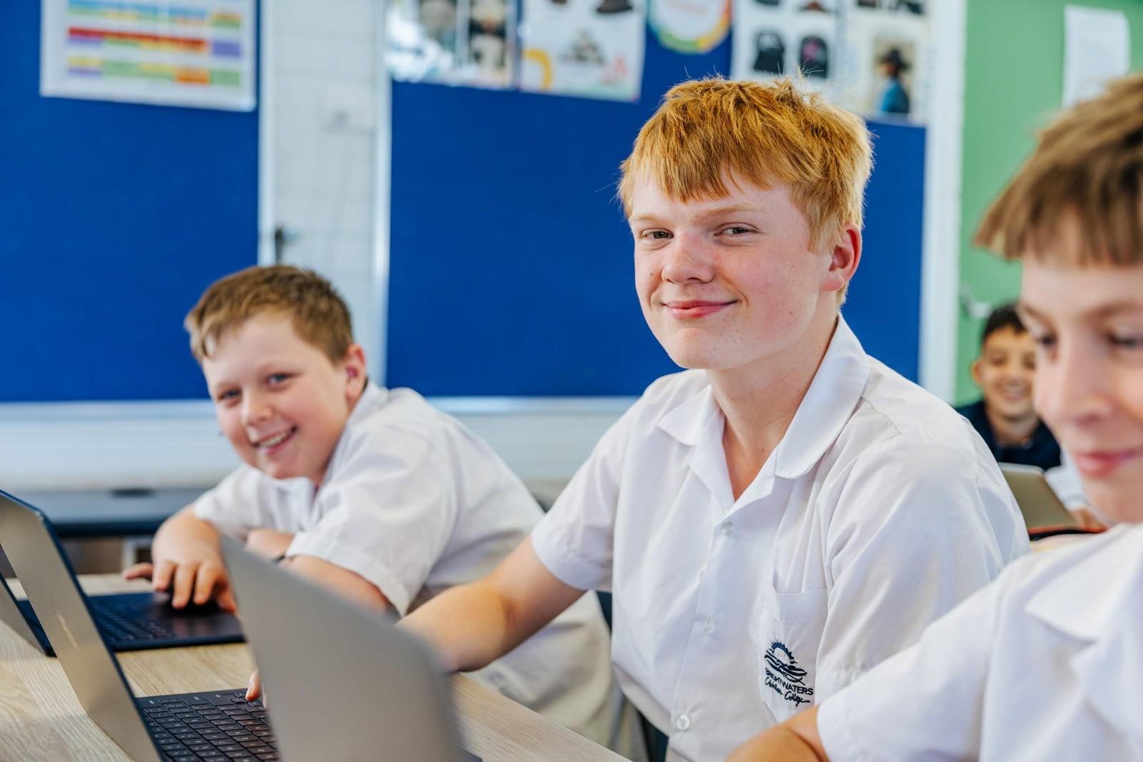 Secondary boys learning on laptops in a supportive classroom near Morisset NSW