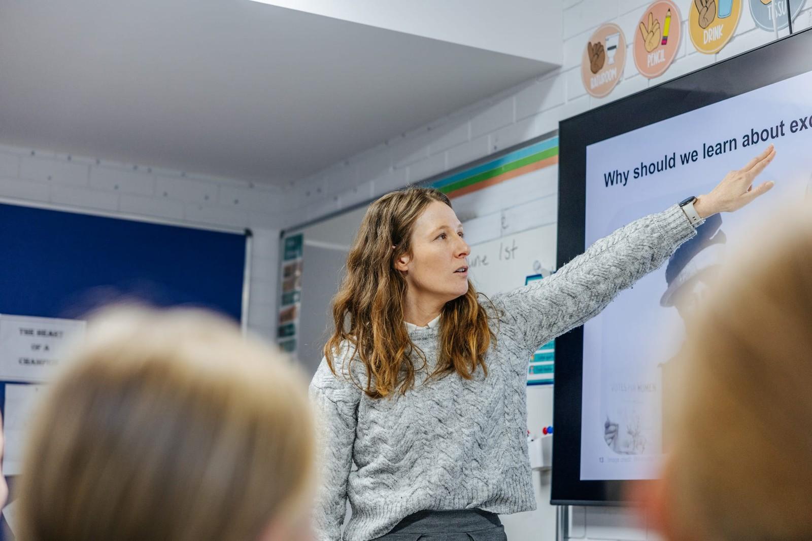 Teacher pointing to a lesson on the smartboard in a Lake Macquarie classroom
