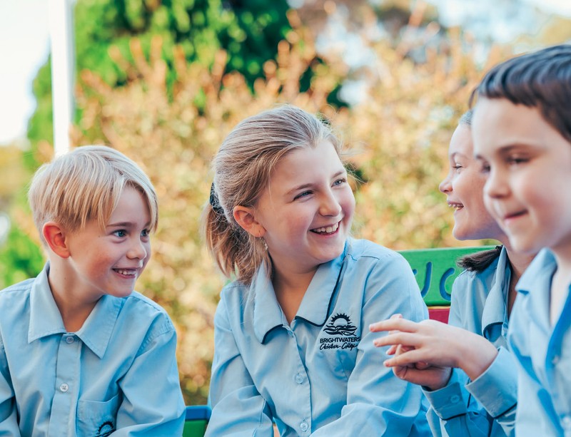 Students laughing on bench