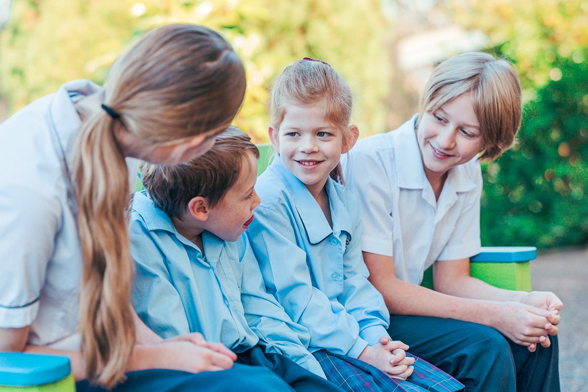 Students of various ages sitting together, looking after each other.